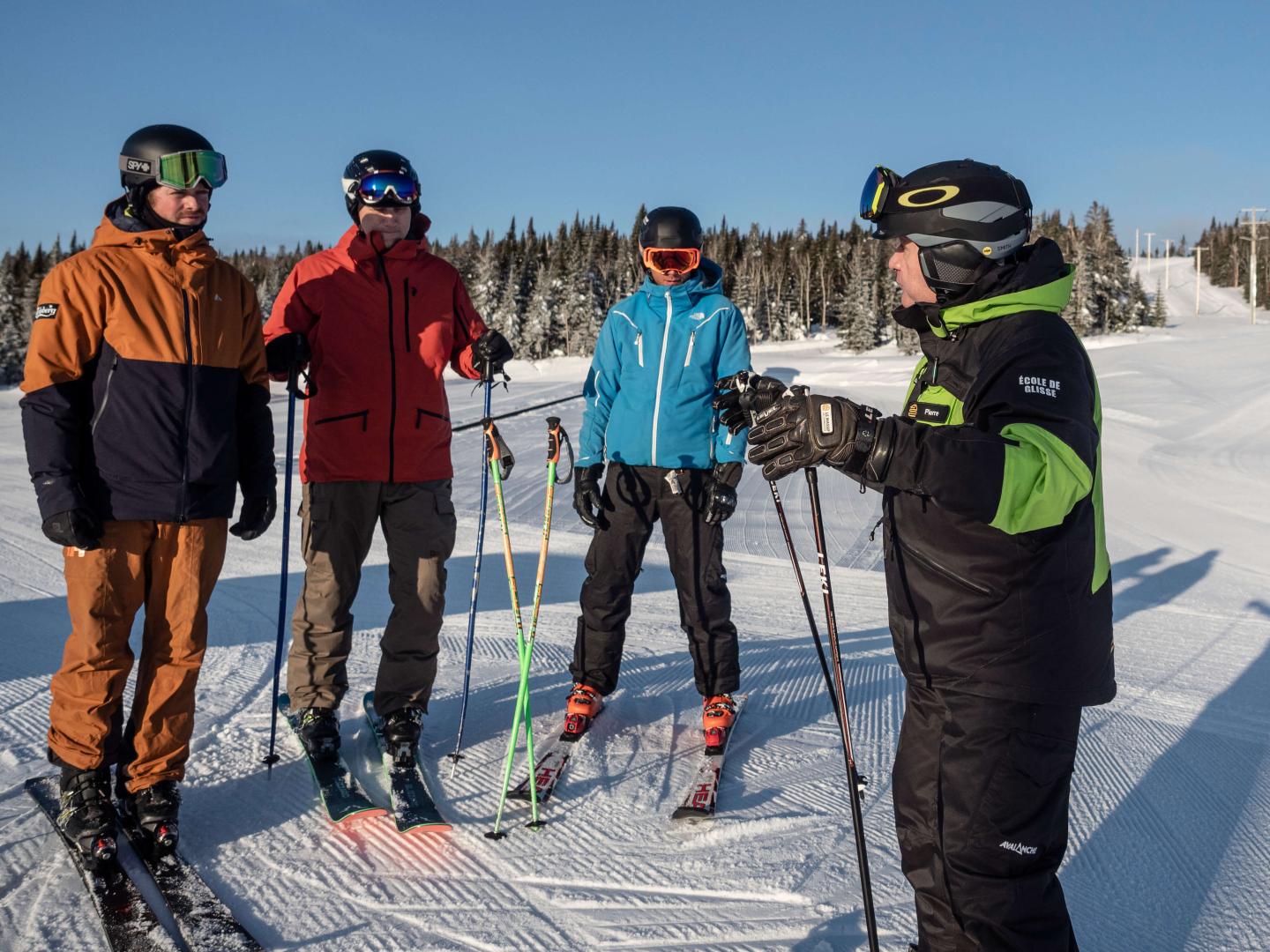 four people take a beginner ski lesson at Le Massif Resort, Quebec