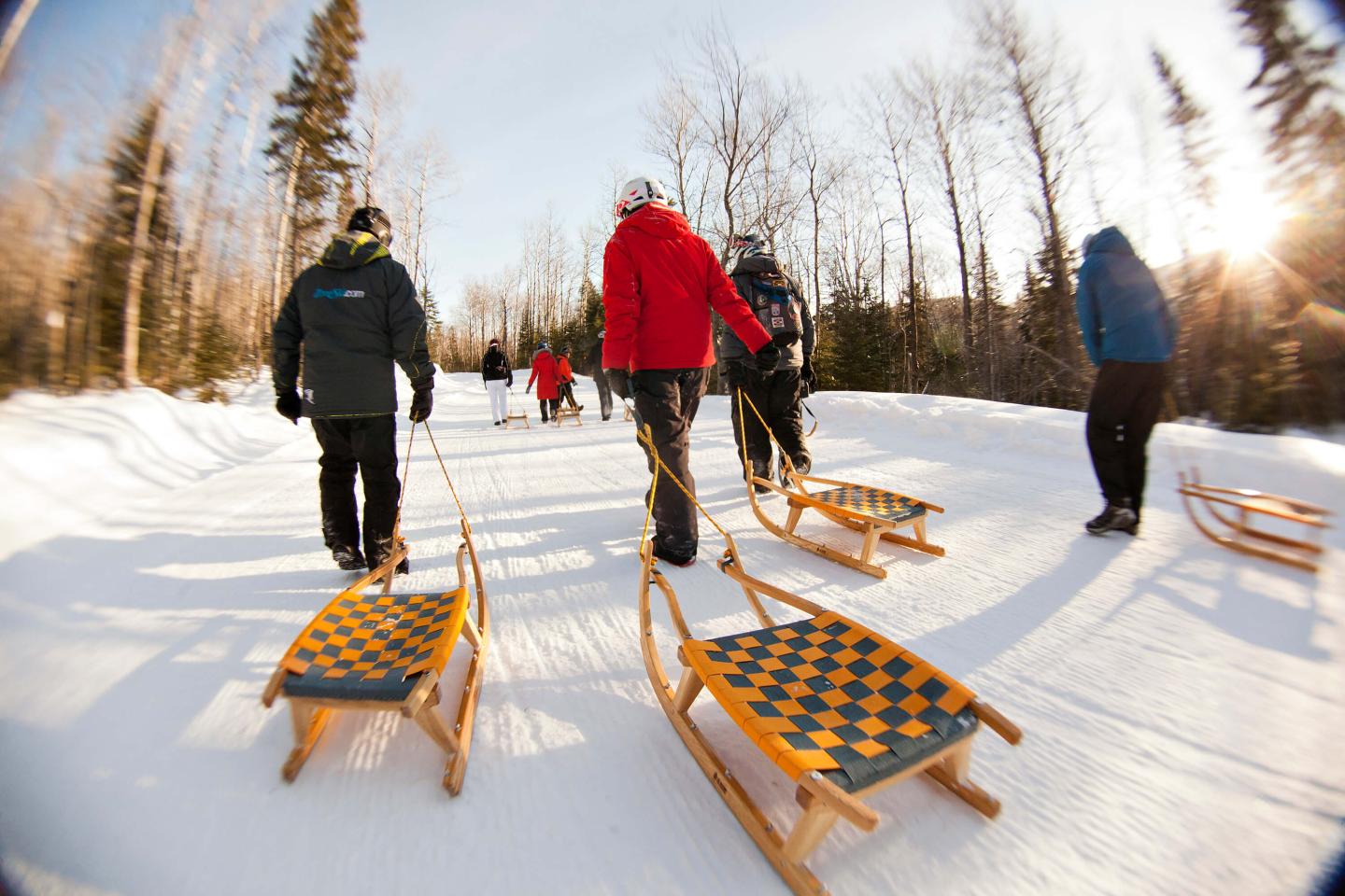 people towing sleds across snow
