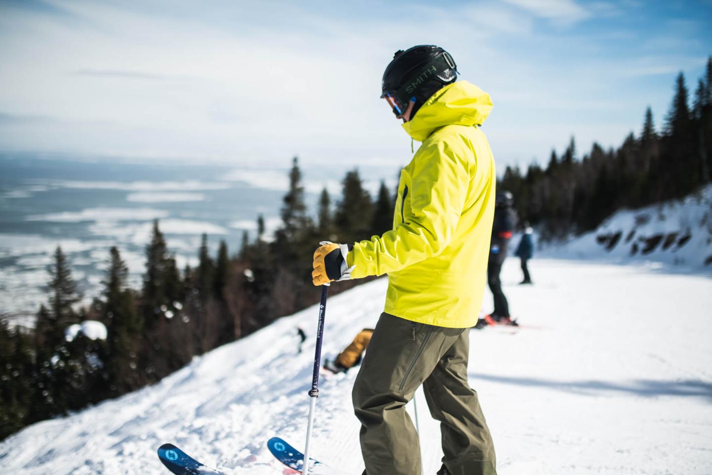 skier poses at the top of the mountain of le massif looking at the next line downhill