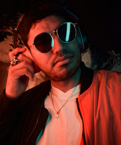 Personne avec lunettes de soleil et casque audio, éclairée en rouge et vert.