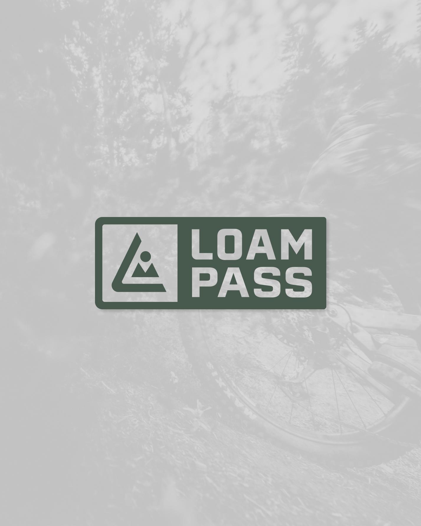 Logo avec triangle vert et texte "Loam Pass". Fond flou de roue de vélo.
