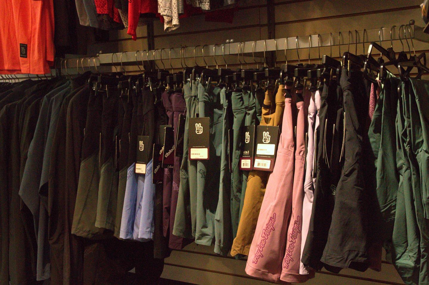 Pantalons colorés et chemises suspendus dans un magasin.