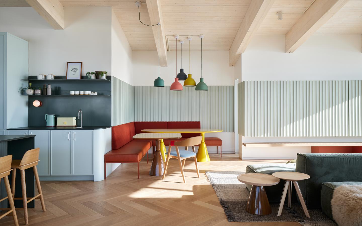 Cuisine ouverte moderne avec luminaires colorés et coin repas.