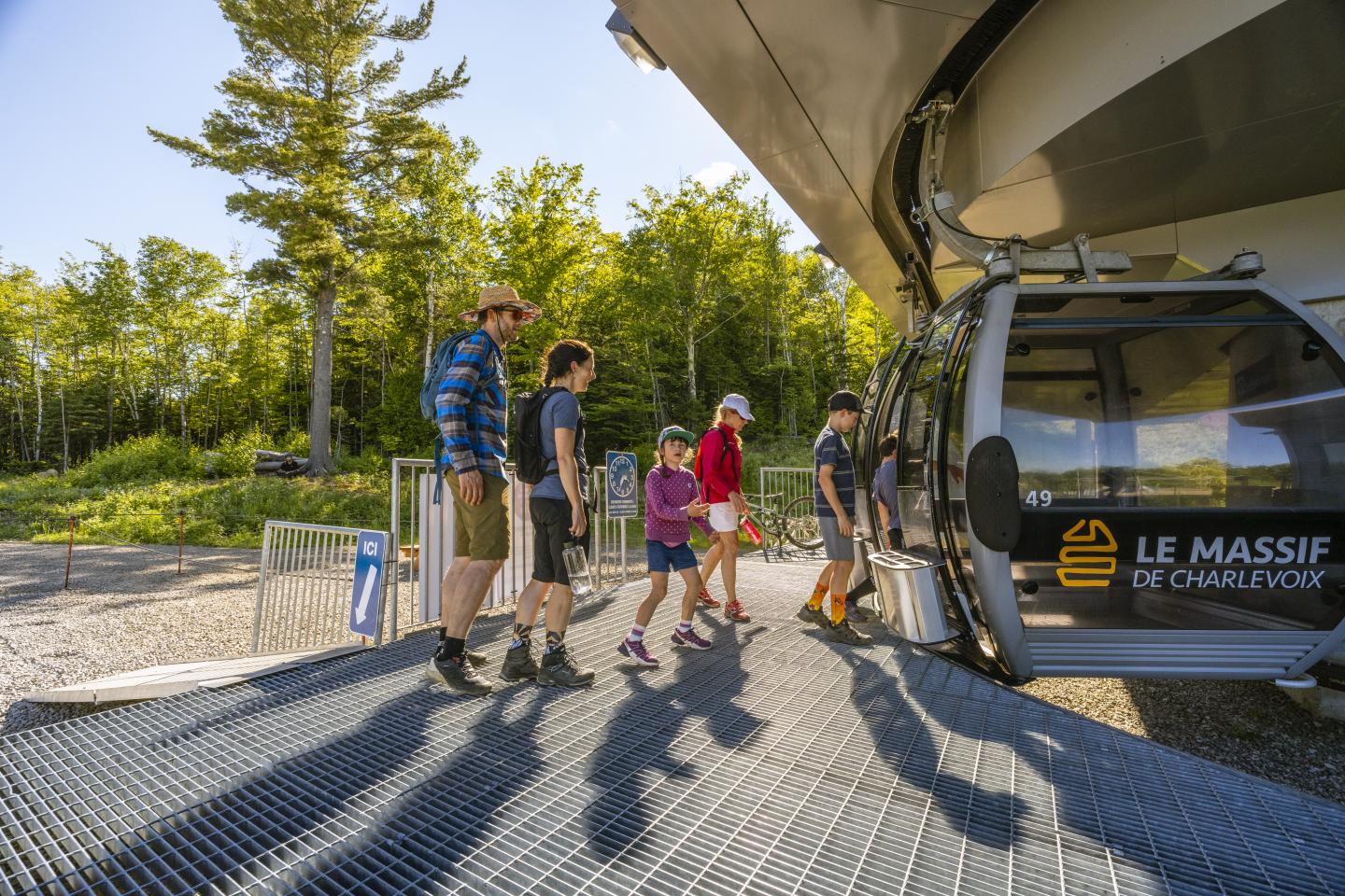 Famille montant dans la télécabine du Massif de Charlevoix, au milieu de la nature.