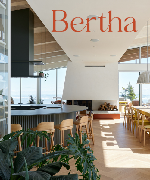 Intérieur moderne avec bar, grandes fenêtres, et chaises en bois clair.