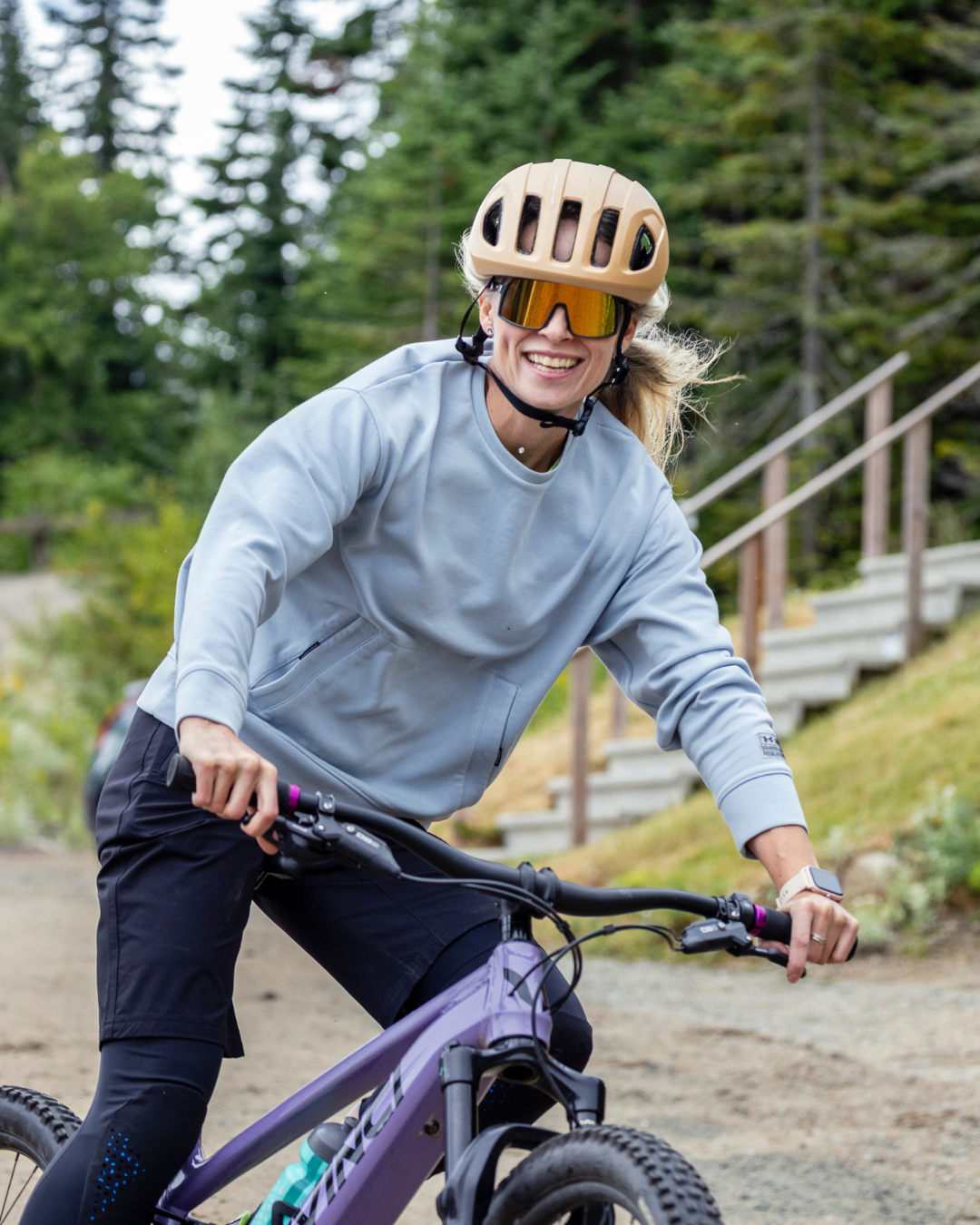 Cycliste souriant en plein air sur un chemin forestier.