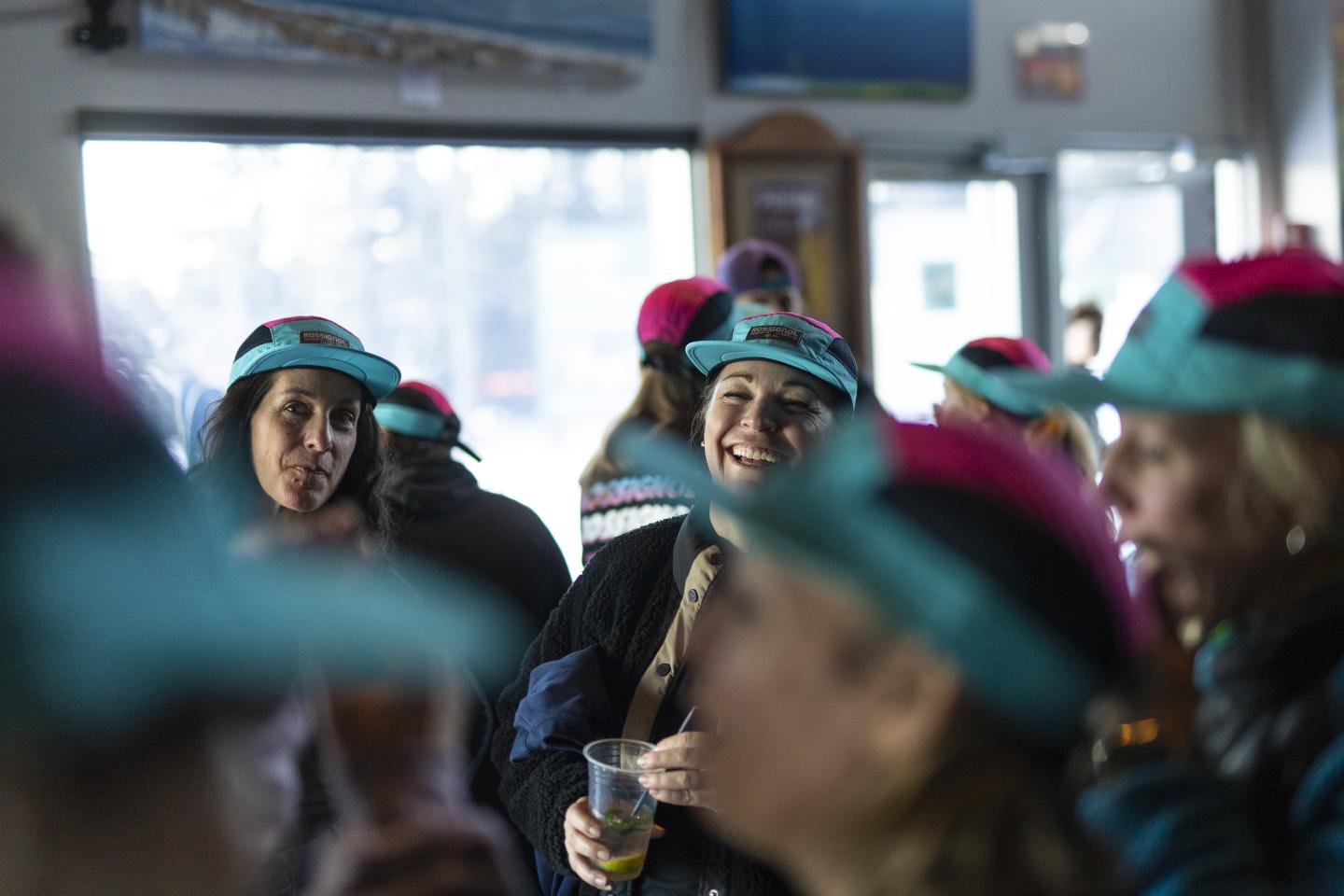 Personnes souriantes, casquettes colorées, espace intérieur animé.