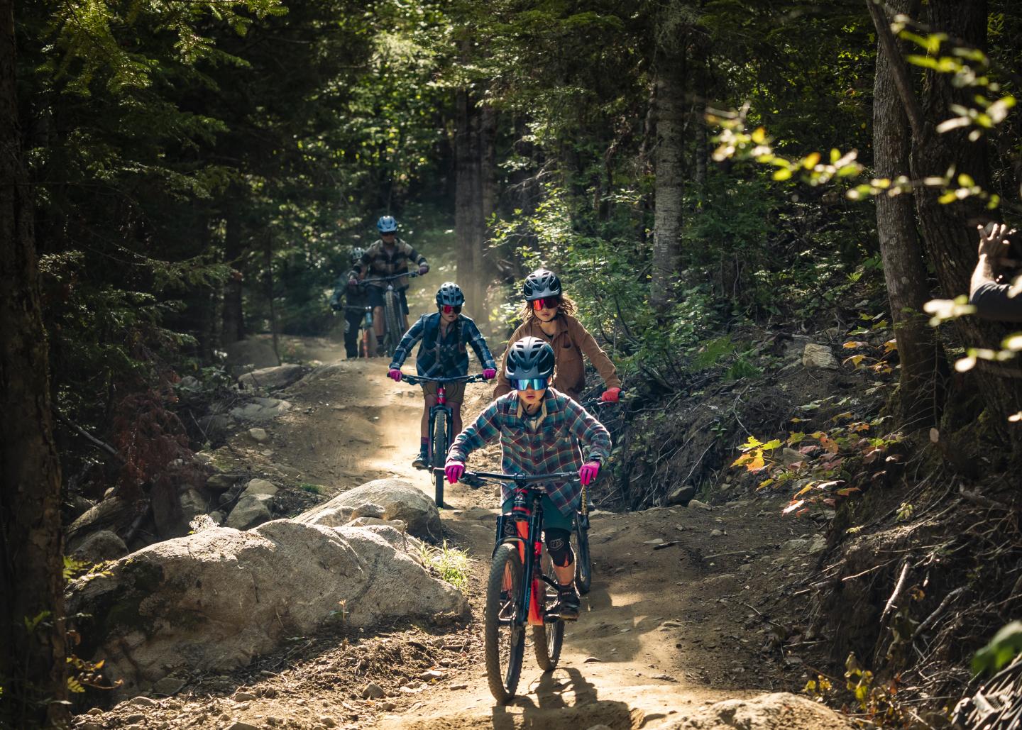 Famille en vélo de montagne sur un sentier forestier du Massif de Charlevoix avec couleurs d'automne