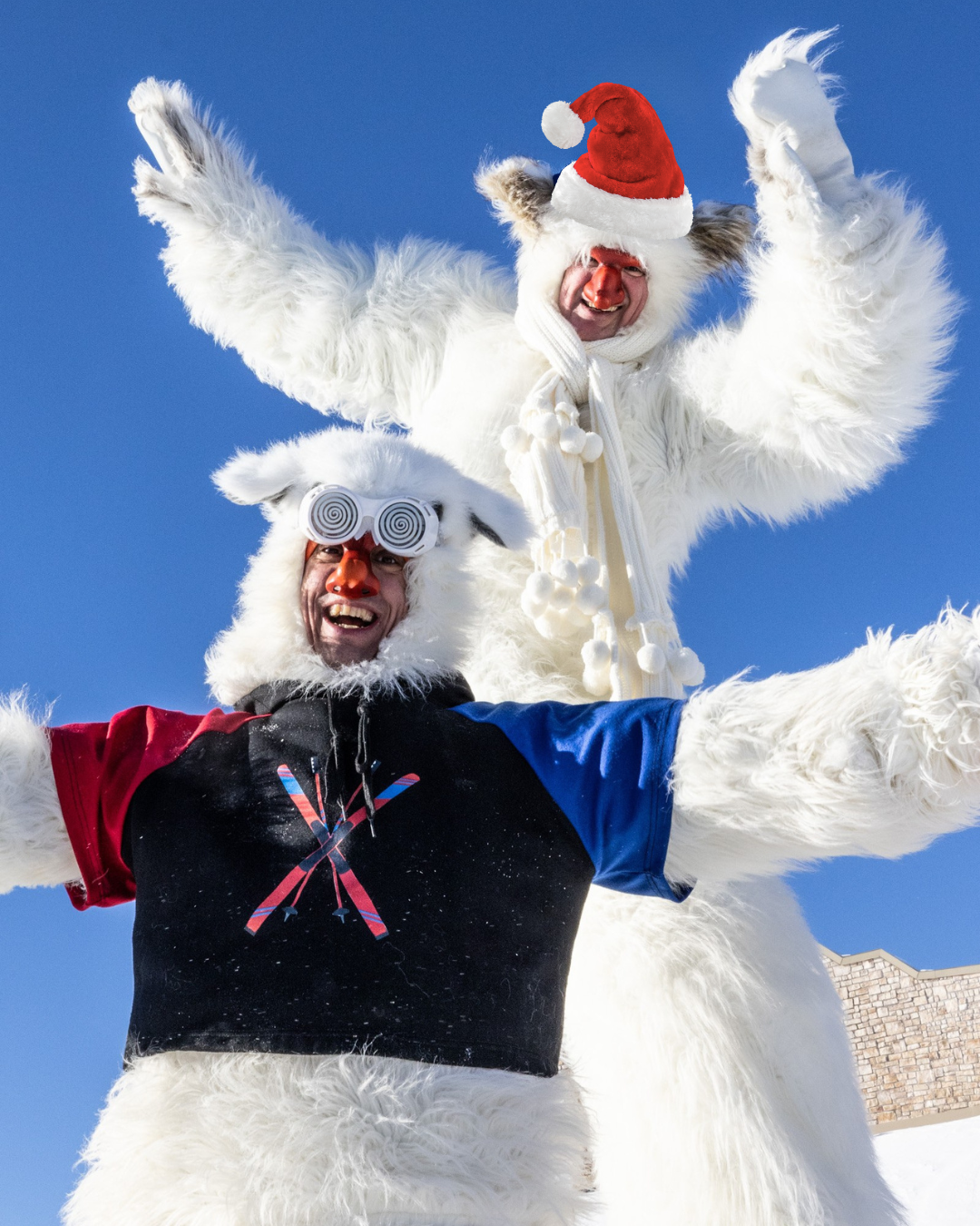 Deux personnes déguisées en yétis sourient sous un ciel bleu.