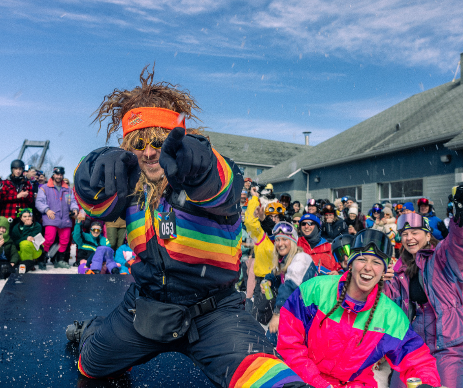 Un groupe en vêtements colorés, joyeux et en train de poser à l'extérieur.