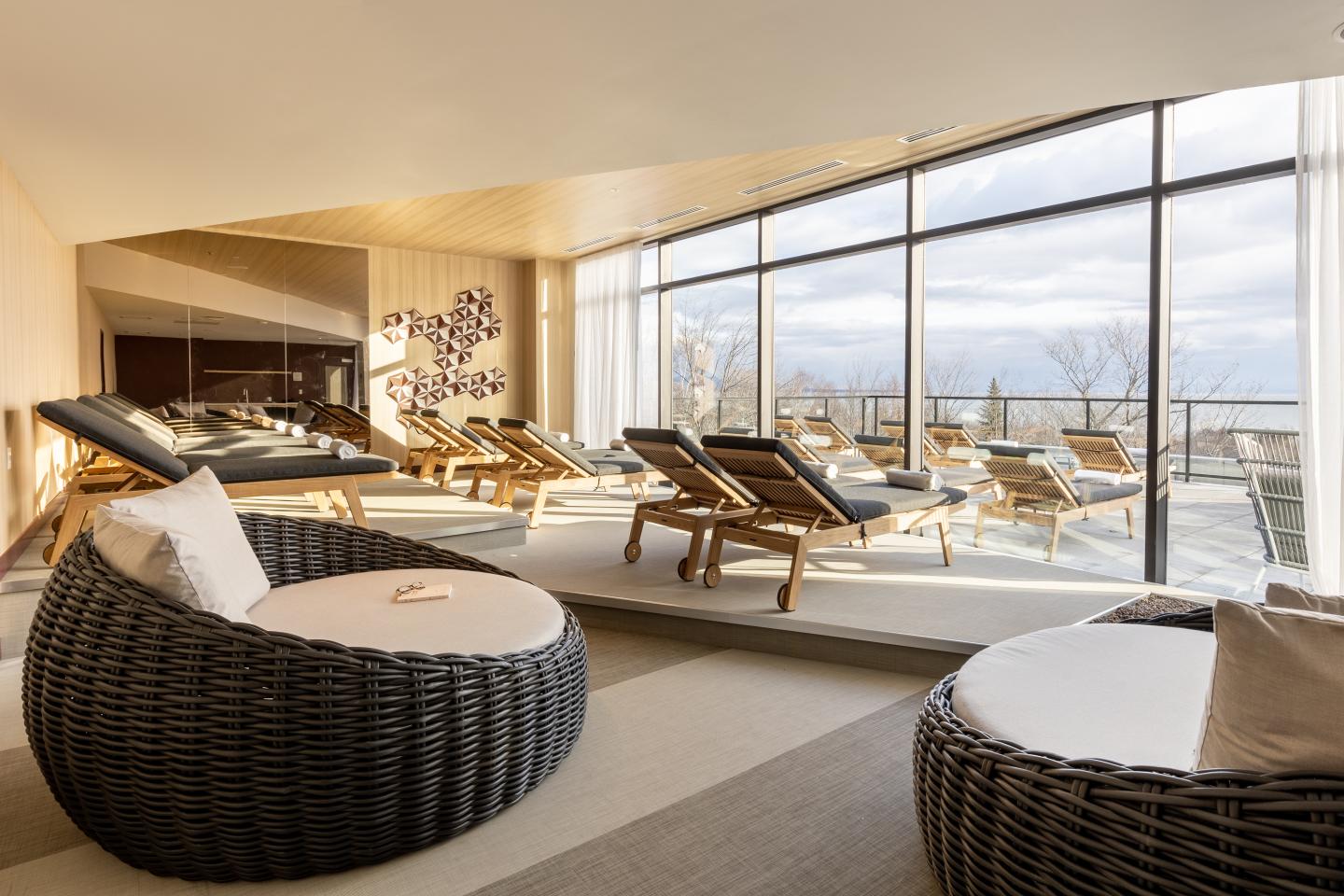 Salle de détente lumineuse avec chaises longues et vue panoramique.