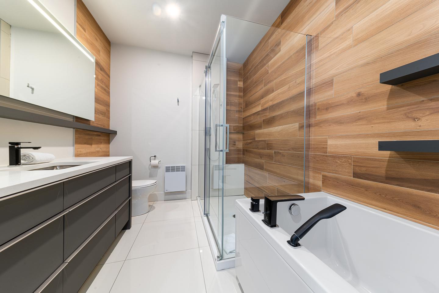 Salle de bain moderne, bois et blanc, baignoire, douche vitrée.
