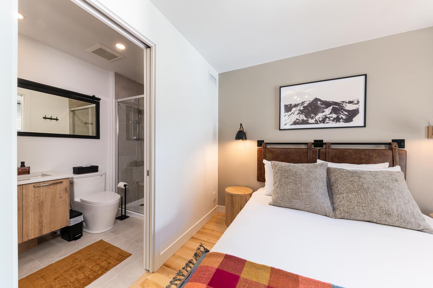 Chambre moderne avec lit double et salle de bain attenante.