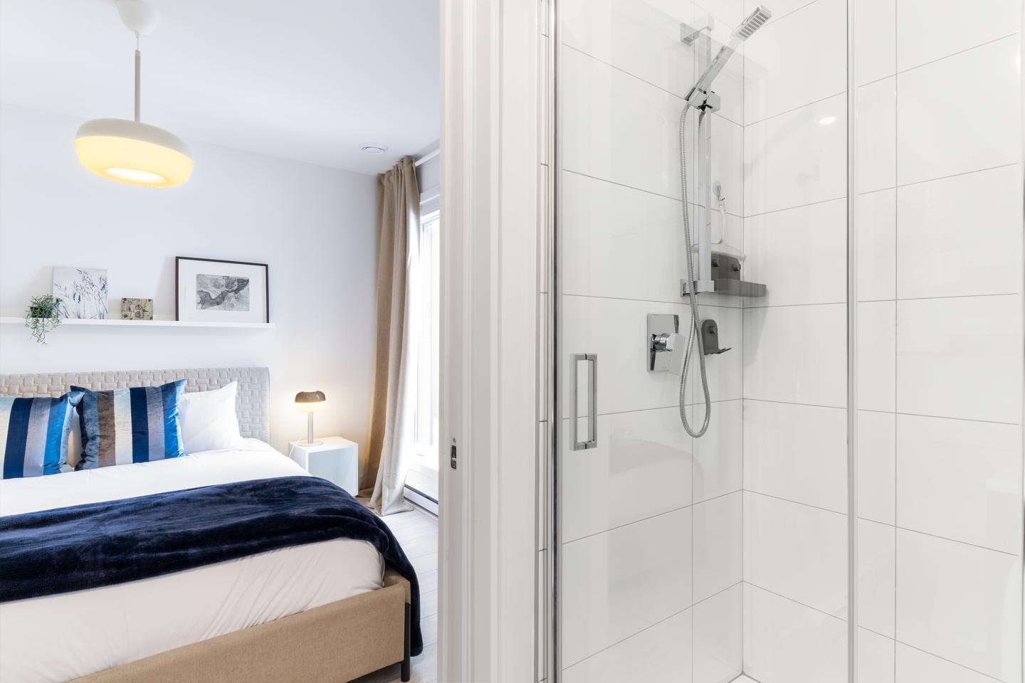 Chambre moderne avec lit double et salle de bain attenante.