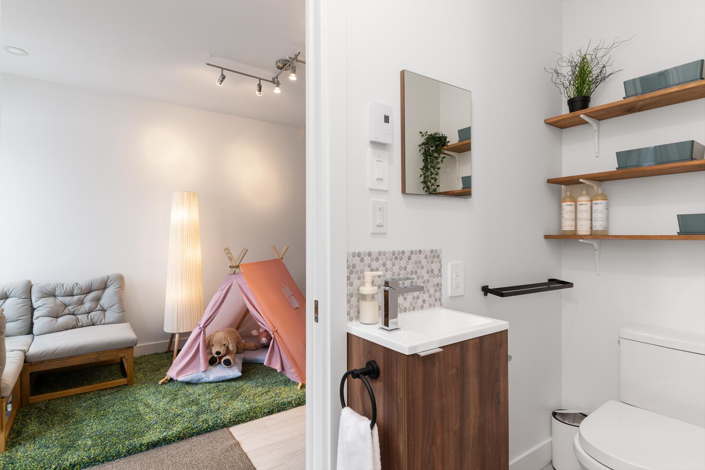 Salle de bains moderne, salon avec tipi rose sur tapis vert.