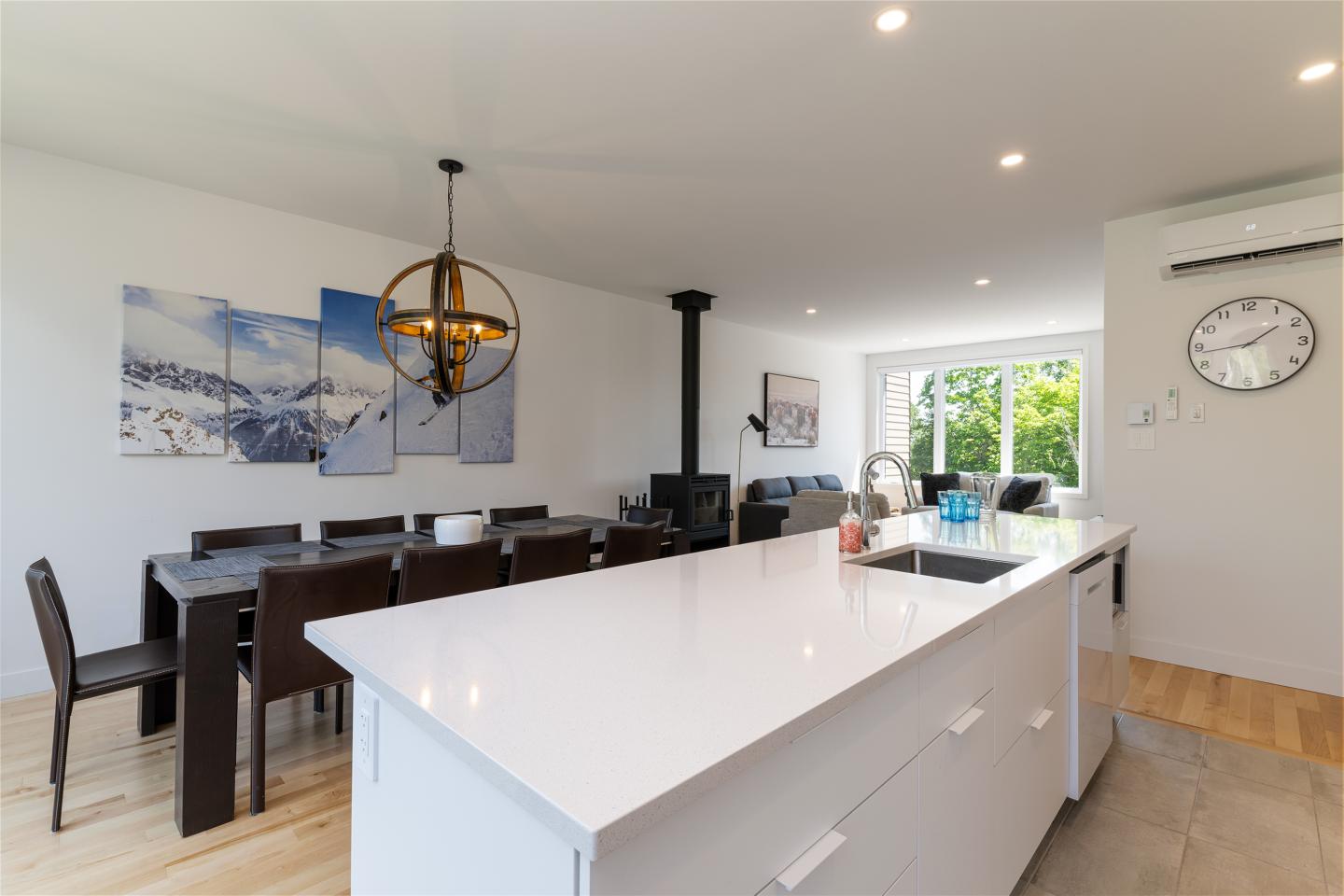 Cuisine moderne avec îlot central blanc et salle à manger attenante, décoration lumineuse.
