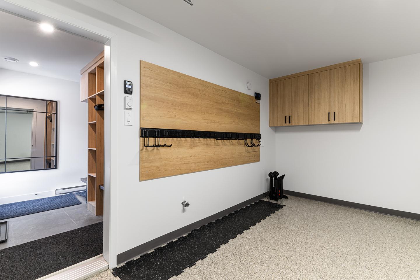 Salle blanche avec étagères et placard en bois, entrée sur la gauche.