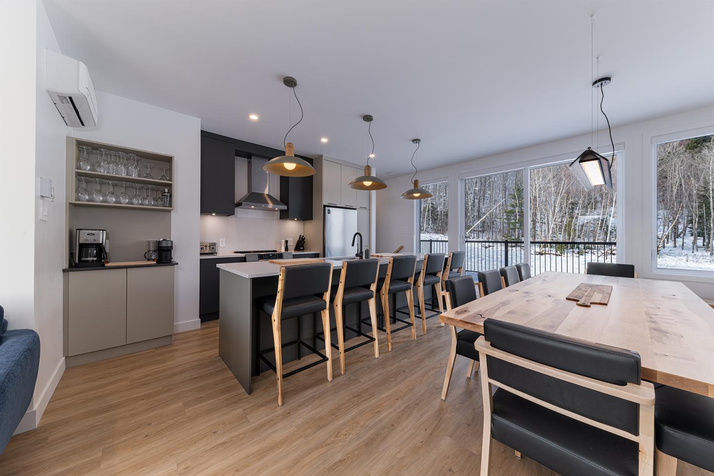 Cuisine moderne avec salle à manger, baies vitrées et lumière naturelle.