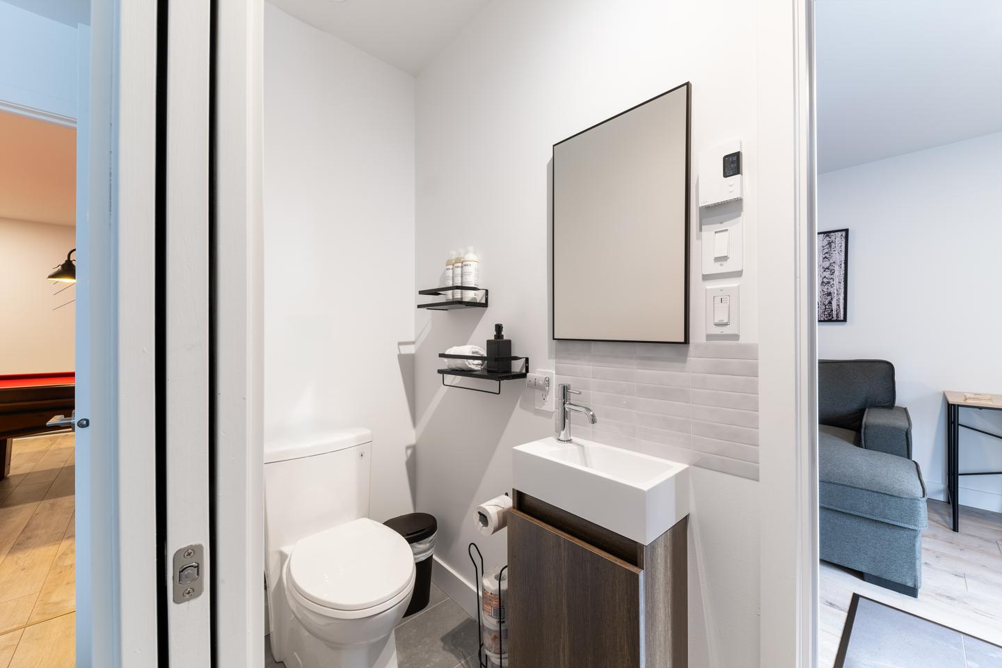 Salle de bain moderne avec lavabo et toilettes, décor minimaliste.