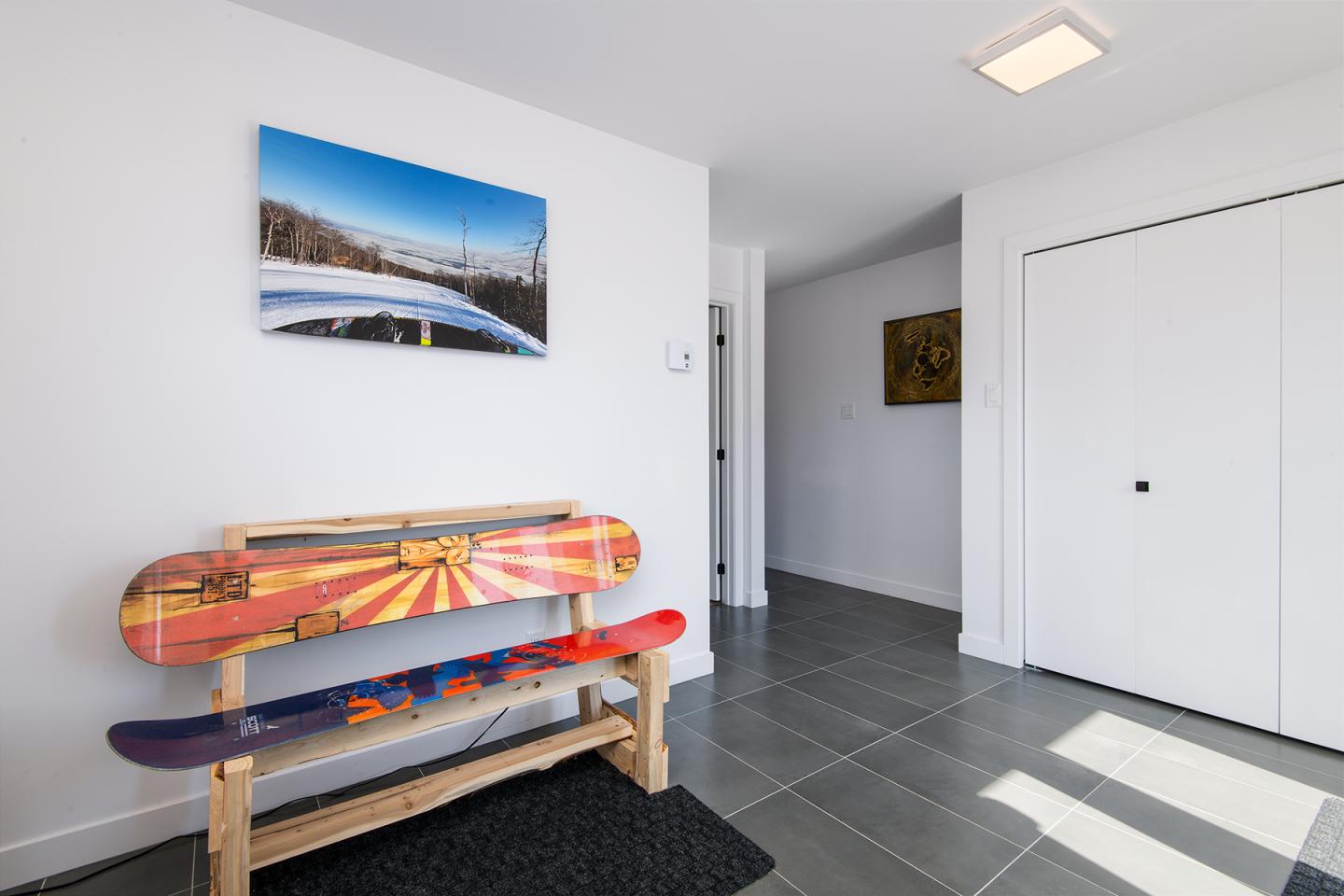 Banc avec planches colorées dans un hall moderne, photo de montagne au-dessus.