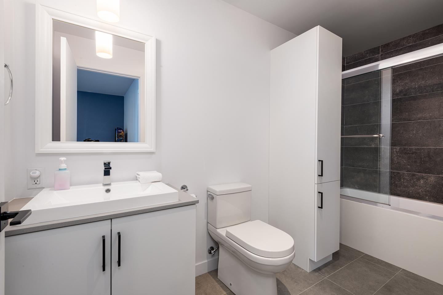 Salle de bain moderne avec lavabo, toilettes et baignoire.