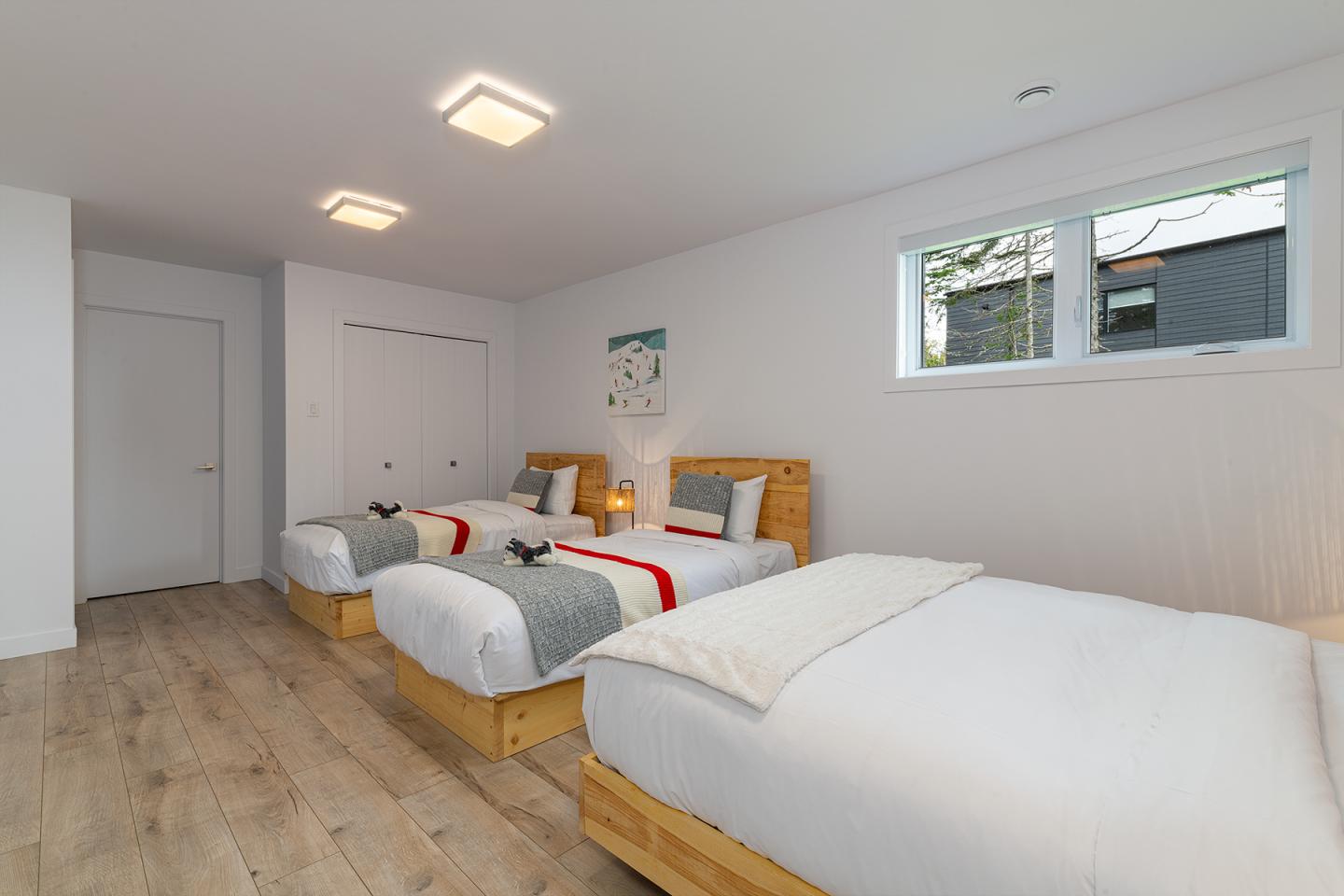 Chambre lumineuse avec trois lits simples alignés.