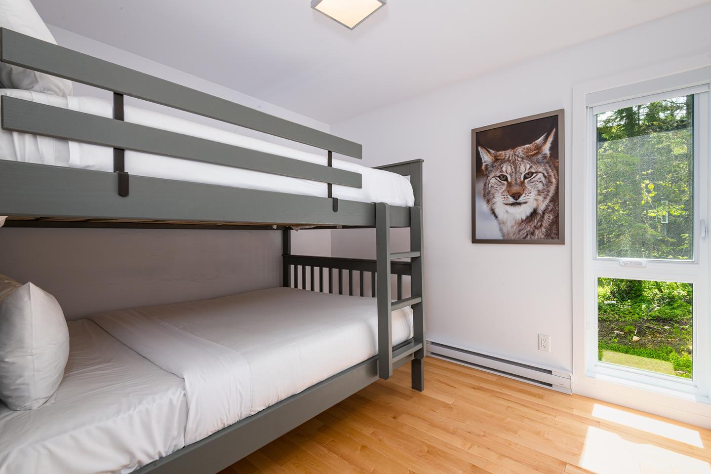 Lit superposé dans une chambre blanche avec une affiche de loup.