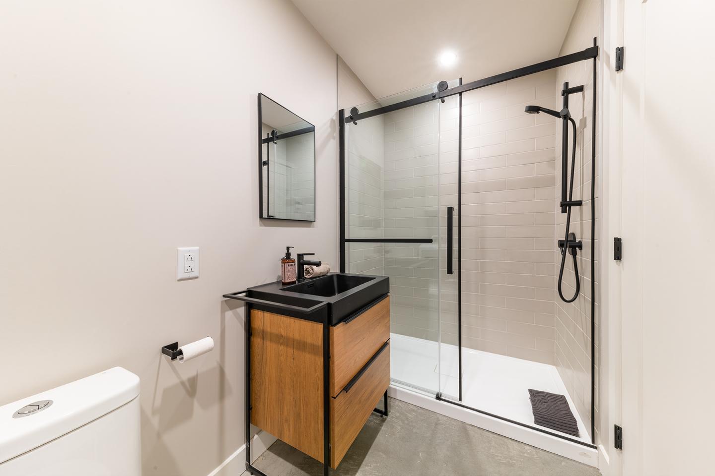 Salle de bain moderne avec douche à l'italienne et meuble vasque en bois.