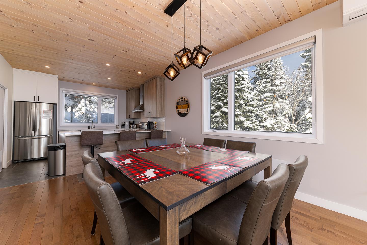 Salle à manger moderne avec vue sur la neige à travers les fenêtres.