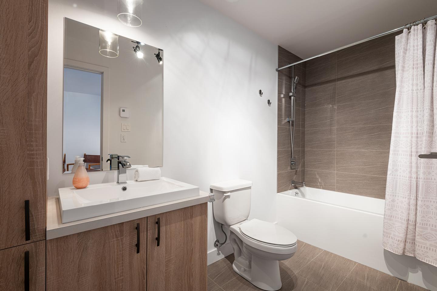 Salle de bain moderne avec lavabo, toilettes et baignoire.