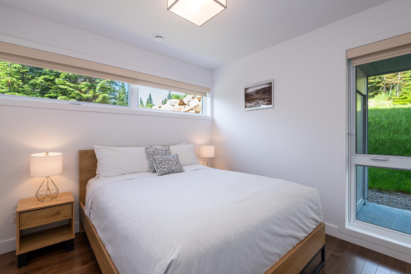Chambre moderne lumineuse avec lit double et lumière naturelle.