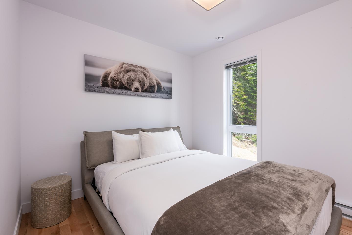 Chambre lumineuse avec lit double, déco ours, fenêtre vue sur jardin.