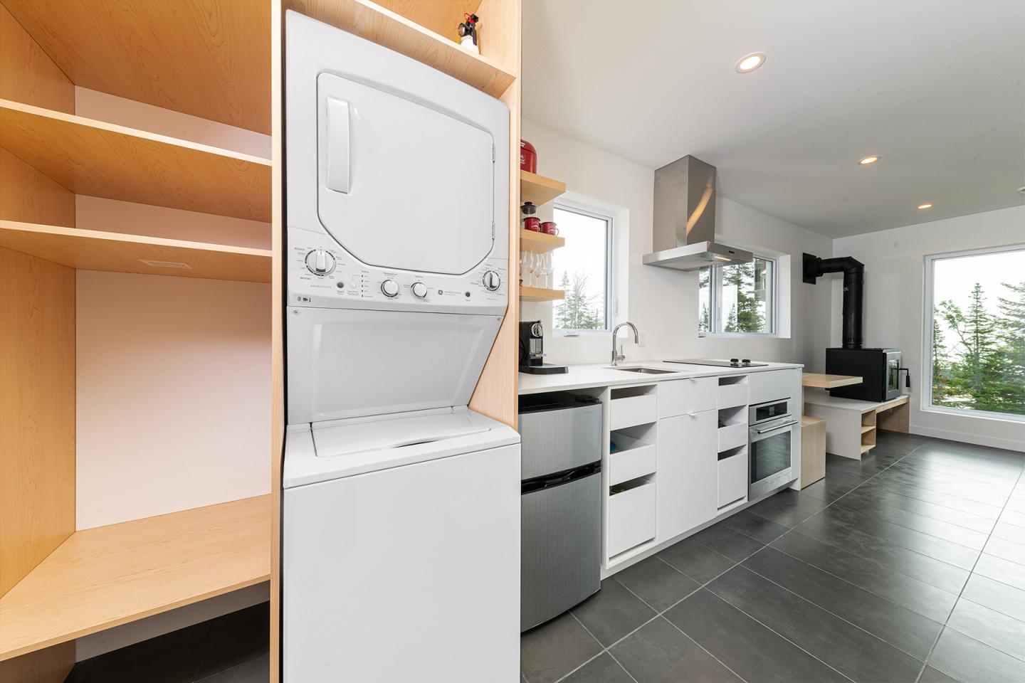 Cuisine moderne avec électroménagers en acier inoxydable et étagères en bois.