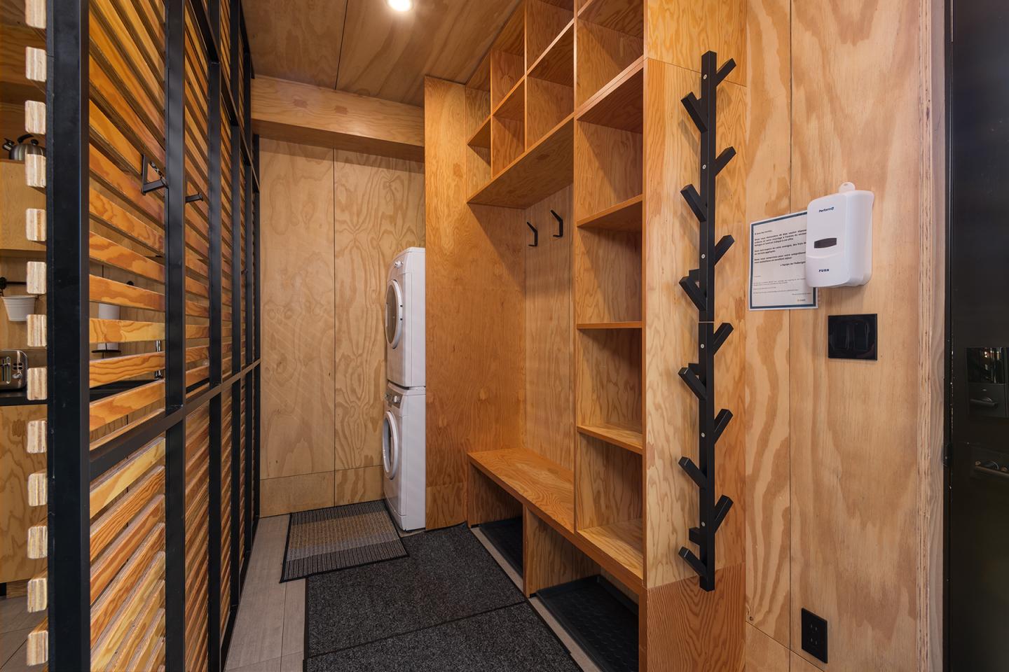 Vestiaire en bois avec étagères, banc et crochets.
