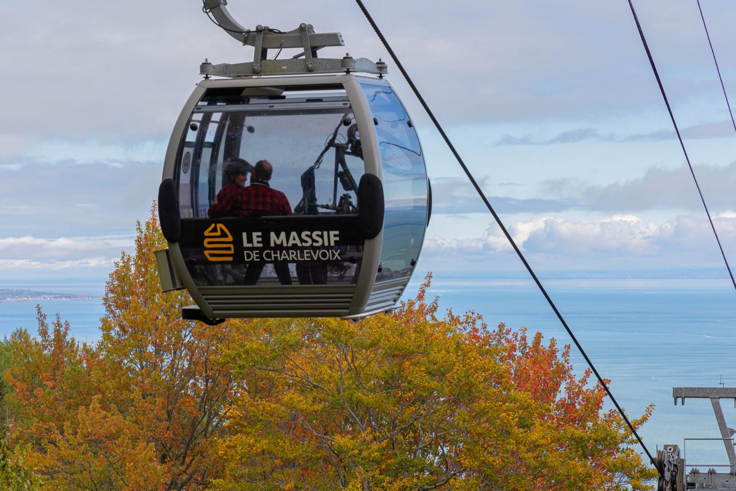 Cabine de téléphérique Le Massif au-dessus des arbres d’automne.