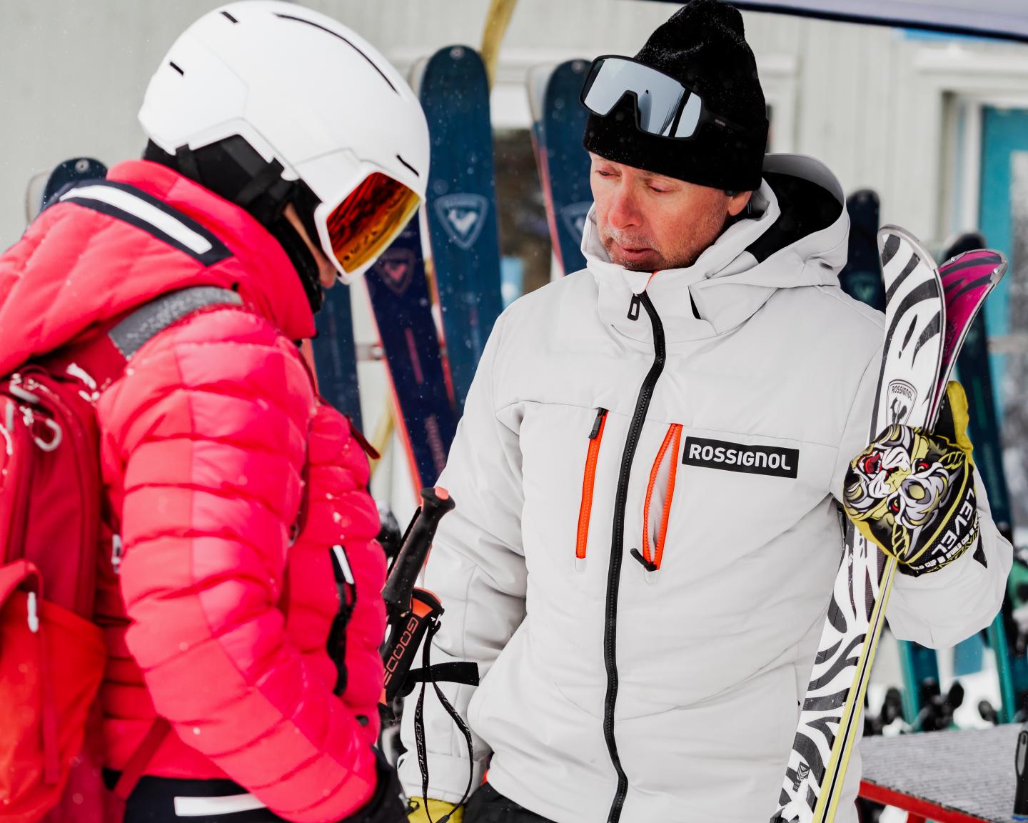 Skieurs en tenue blanche et rouge discutant près des pistes.