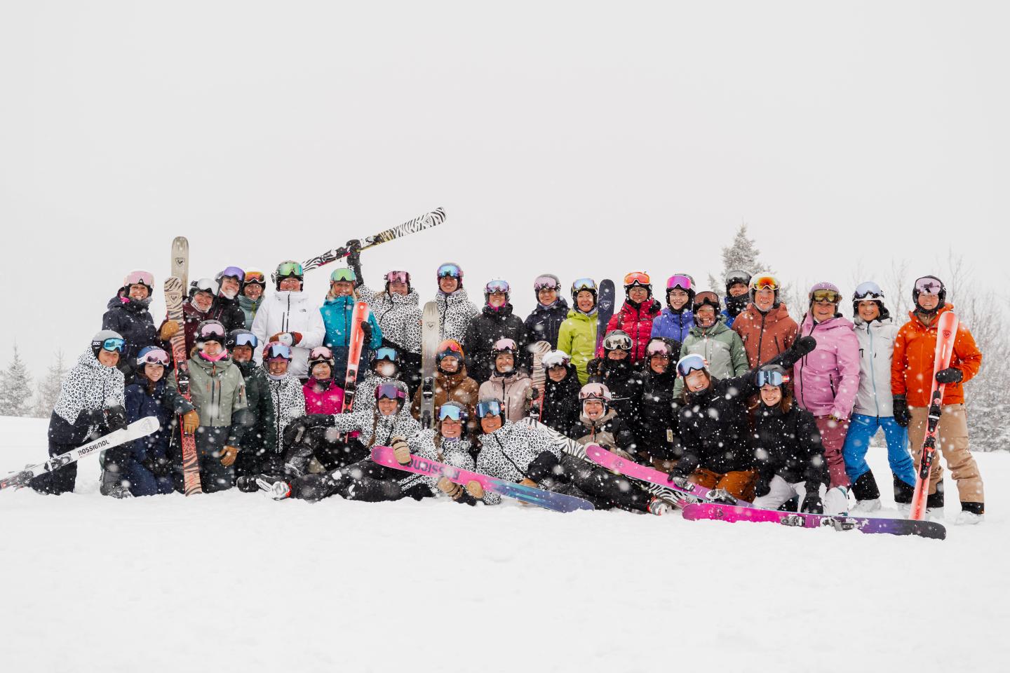 Groupe de skieurs et snowboardeurs posant dans la neige avec leurs équipements.